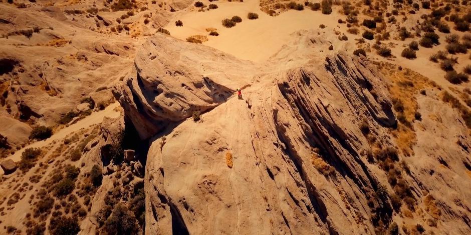 Tracy helps Ellen across the top of a rock formation.