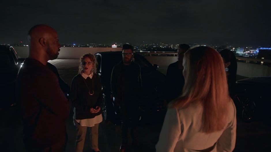 Geoffrey, Stacey, Dale, Victor, Tina, and Leslie discuss the plan on the roof of the parking garage.