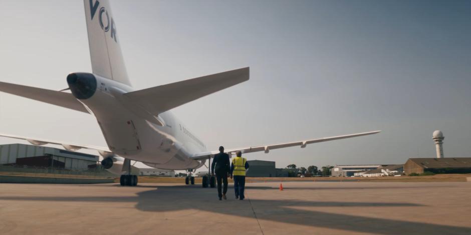 Daniel Barton walks towards his plane with a member of his ground crew.