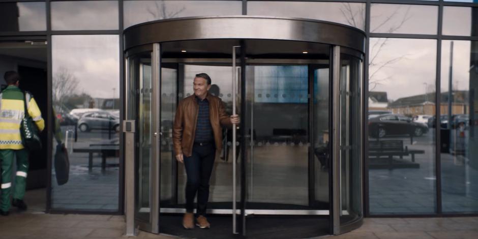 Graham walks through the revolving door with a smile on his face.