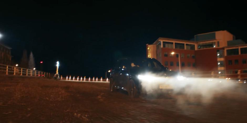 The government vehicle speeds backwards towards the edge of the construction.