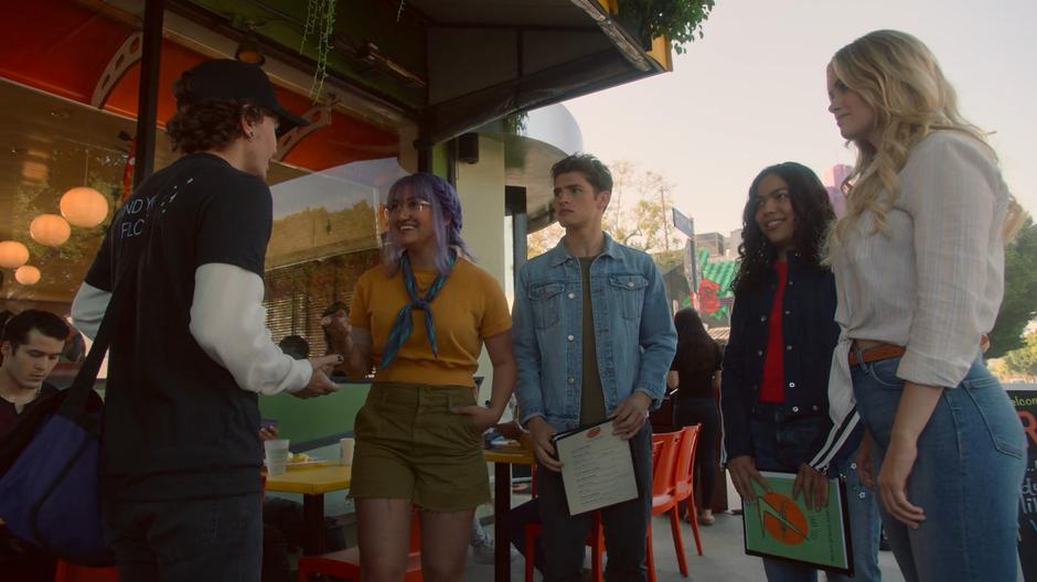 Chase, Molly, and Karolina watch as Gert nerd-flirts with the Corvus rep Max.