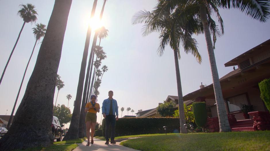 Gert and Chase walk down the sidewalk with Gert focused on her Wiz Phone Corvus.