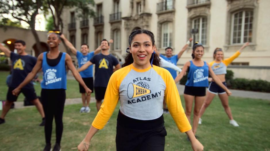 Molly leads the cheer squad in practice on the lawn outside the classrooms.