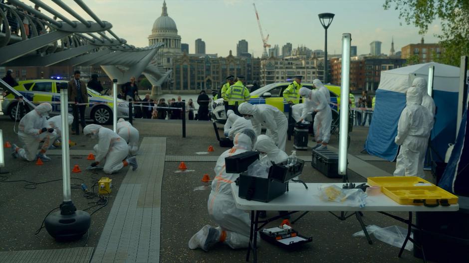 Crime scene techs collect evidence in the daylight.