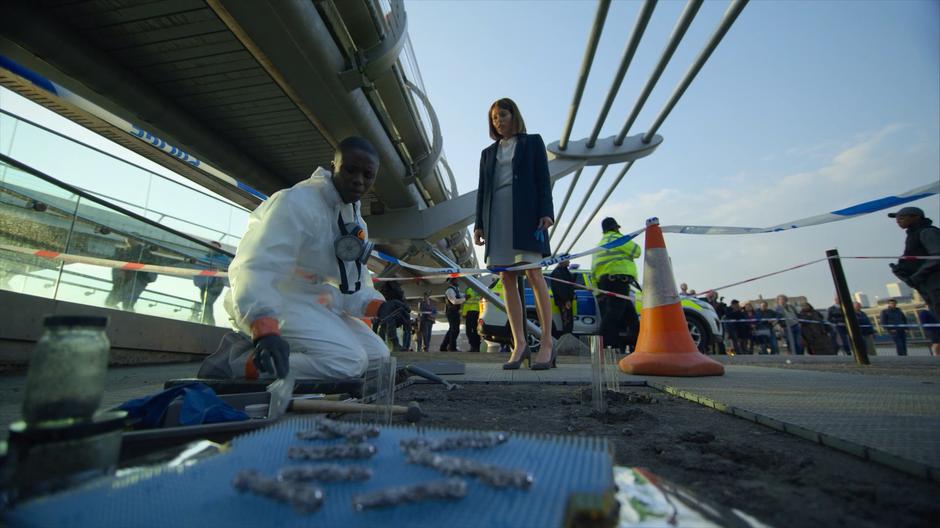 Myfanwy talks to one of the crime scene techs about the strange bits of metal found in the ground.