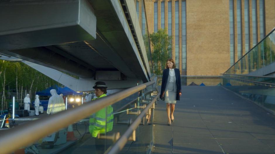 Myfanwy walks down the ramp leading from the bridge to the crime scene.