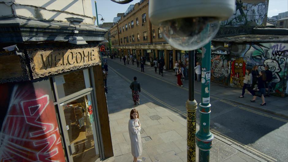 Myfanwy glances around the street before seeing the CCTV camera watching.