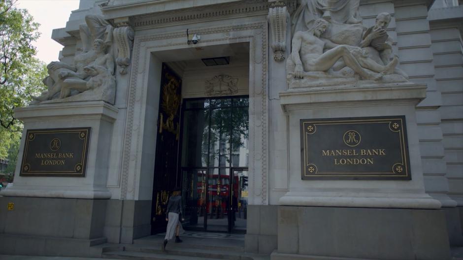 Myfanwy walks up the front steps of the bank.