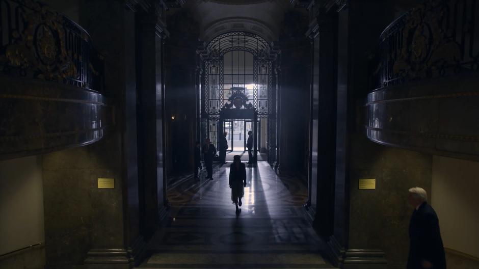 Myfanwy walks through the lobby of the bank looking for the safe deposit boxes.