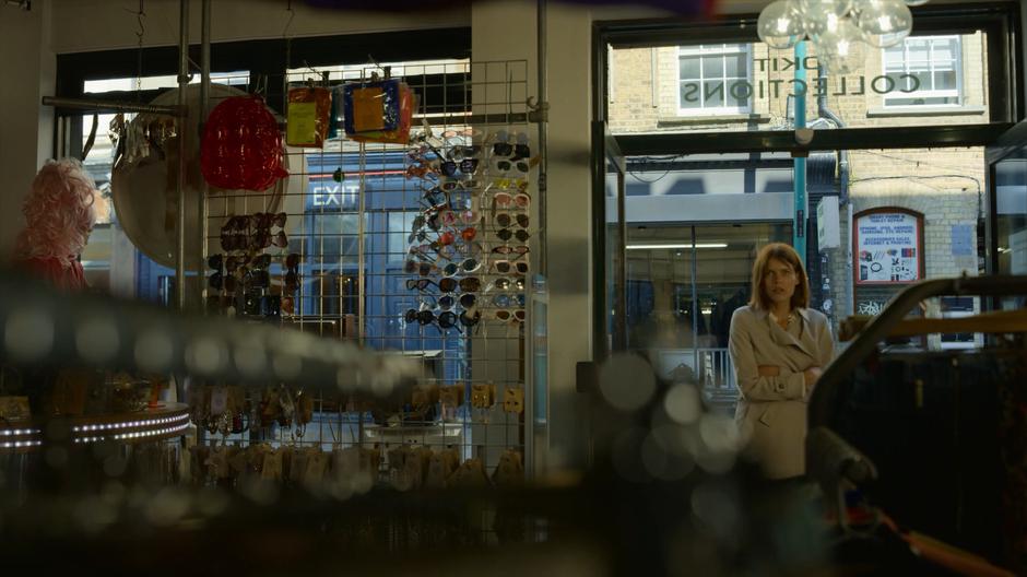 Myfanwy holds herself as she looks into the clothing store.