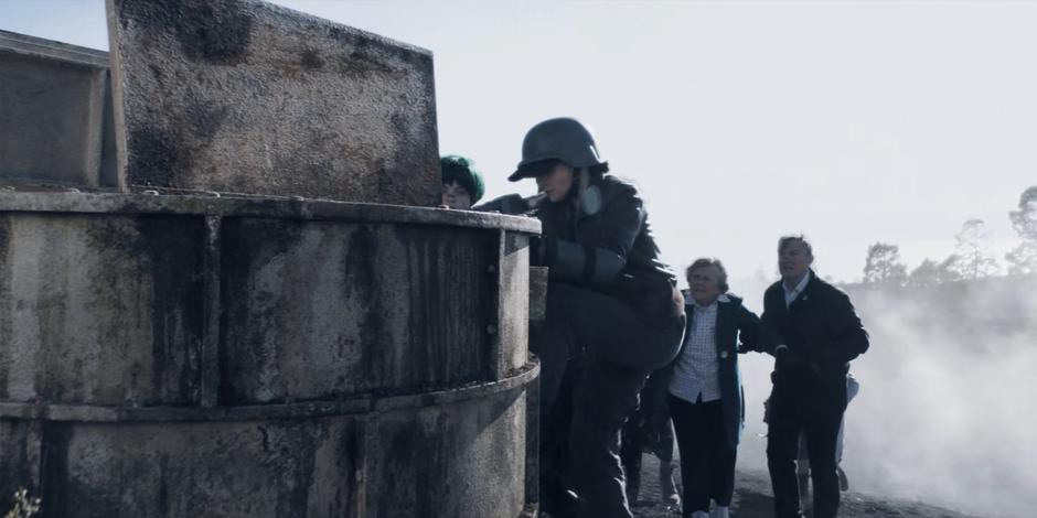 Kane climbs up to head into the shaft while the others line up behind her.