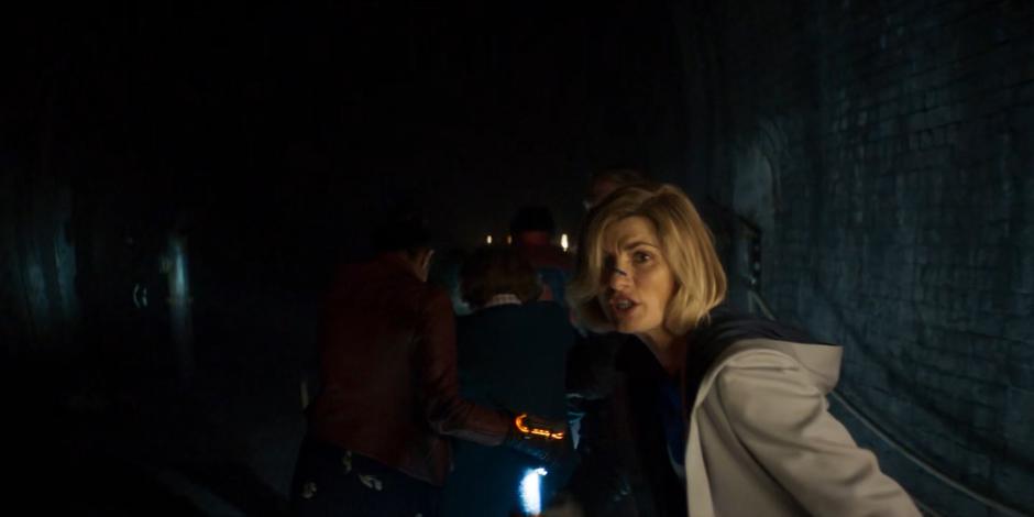 The Doctor looks over her shoulder at the pursuing Dregs as she follows the group.