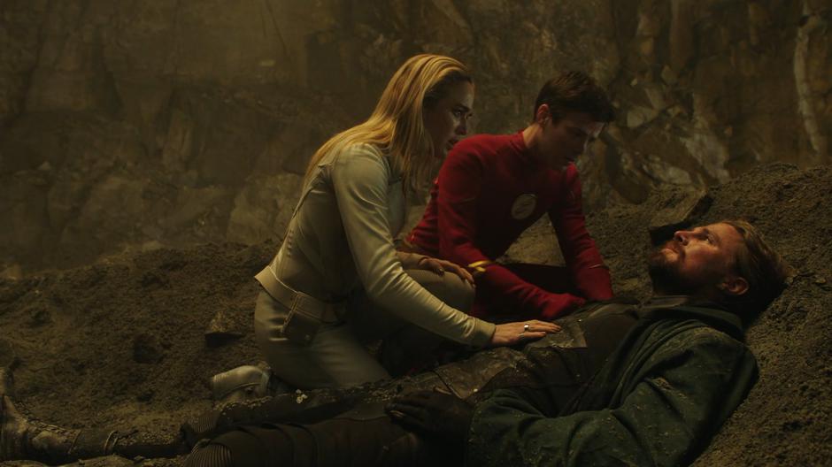 Sara and Barry kneel over a dying Oliver.