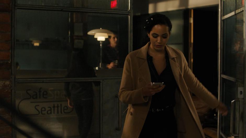 Macy looks down at the text message from Julian as she walks out the door.