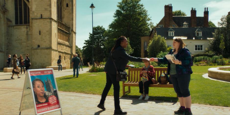 Ruth hands a young woman one of her brochures after giving her some facts about the cathedral.