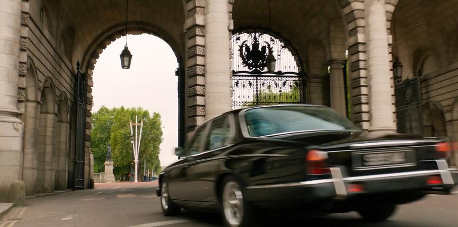 H races through the arches in his car.