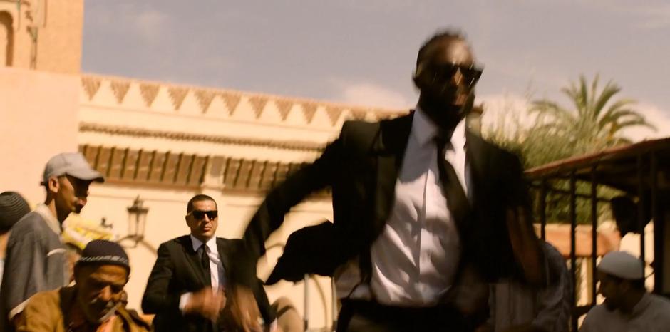 M.I.B. agents run through the market after H.