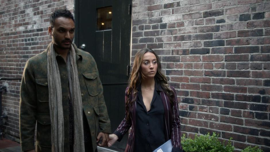 Julia lets go of Penny's hand to check out her book after arriving in the alley.