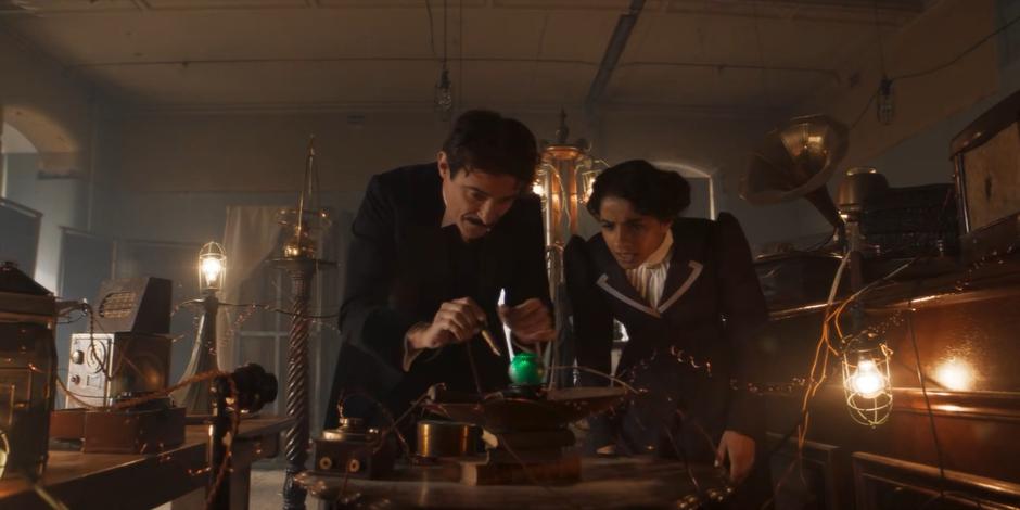 Nikola Tesla and Yaz lean over and examine the strange ball.