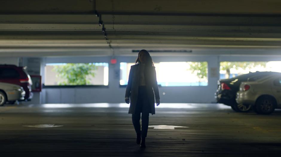 Iris walks through the parking garage looking for her whistleblower.