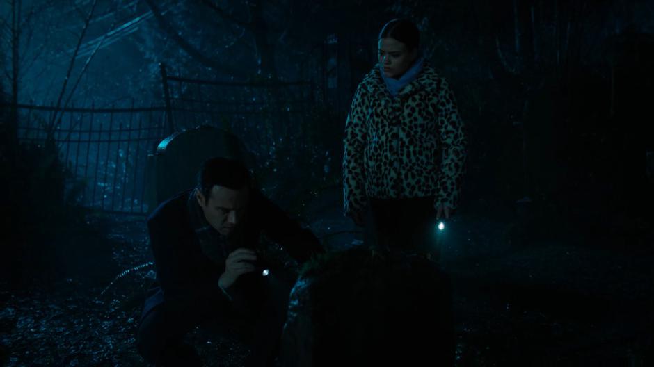 Harry and Maggie examine on of the gravestones.