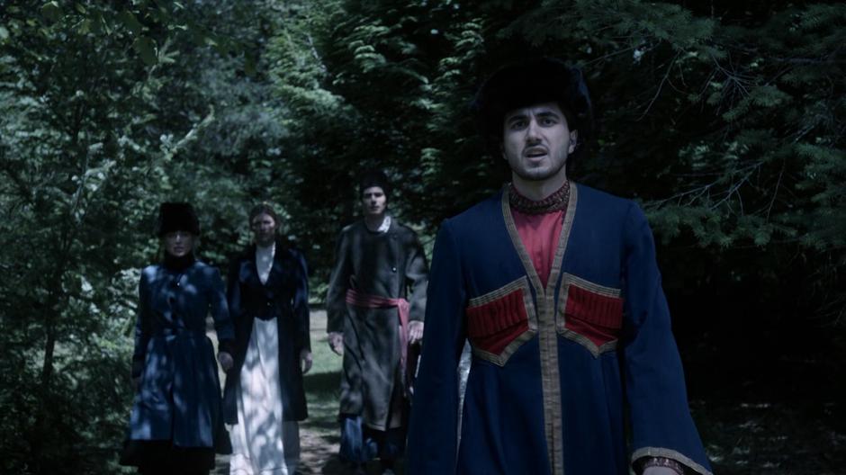 Sara, Ava, Ray, and Behrad approach the edge of the cemetery to keep an eye on the funeral.