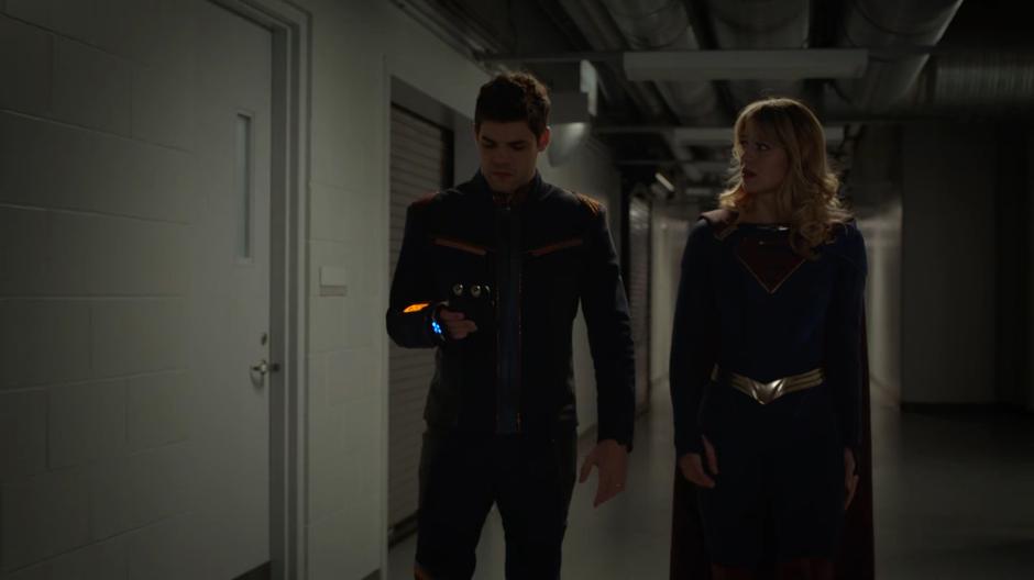 Kara watches Winn as he looks down at his radiation detector.