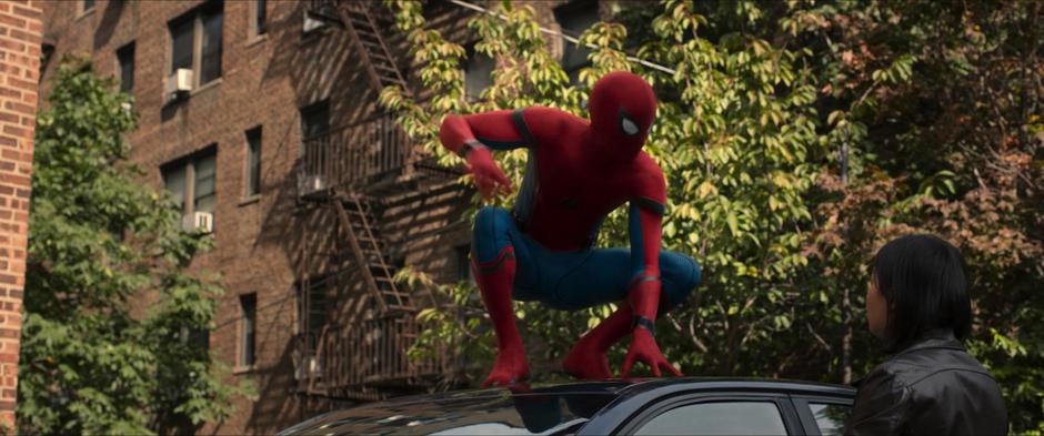 Peter lands on the roof of the car that he believes the guy is trying to steal.