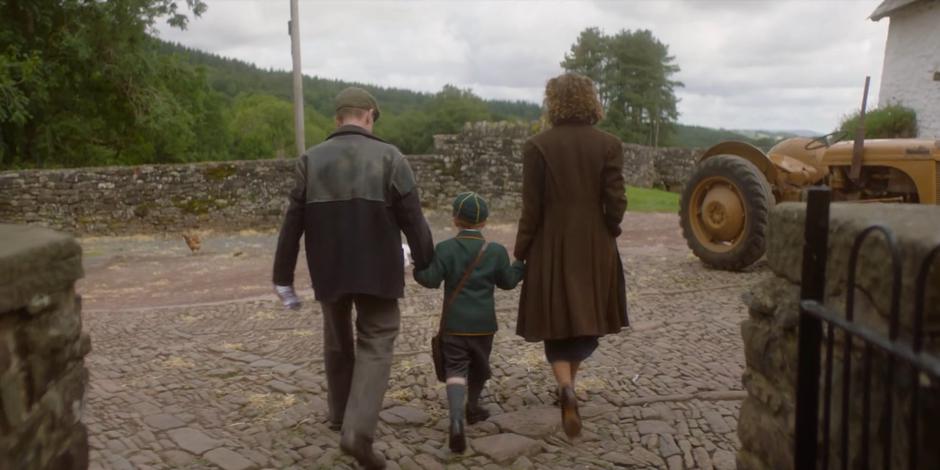 Patrick and Meg hold Brendan's hand and walk with him on his first day of school.