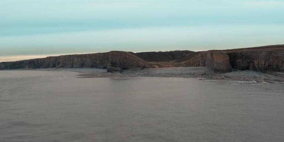 Establishing shot of the camp viewed from over the water.