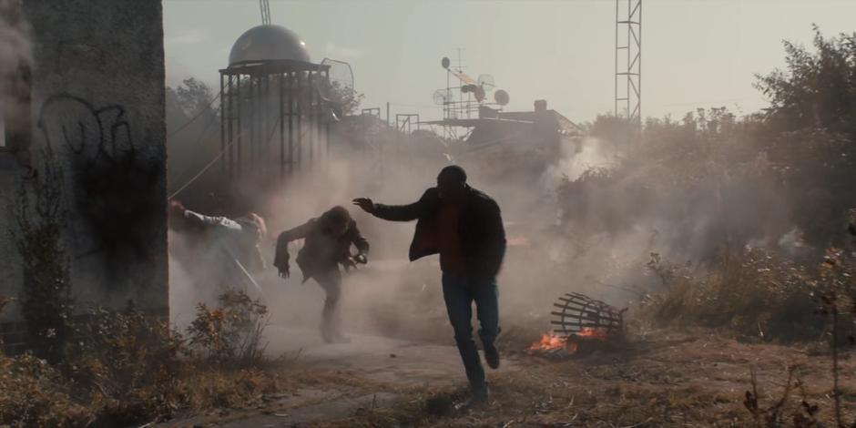 The Doctor, Ethan, and Ryan run from the ruined church after the Doctor threw a bomb at the Lone Cyberman.