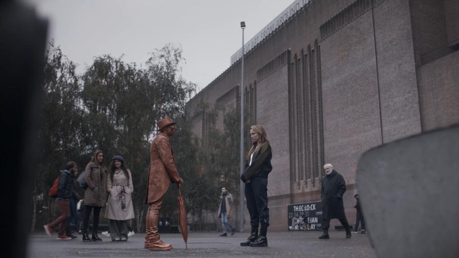 Constantin approaches to find Villanelle staring at a human statue.