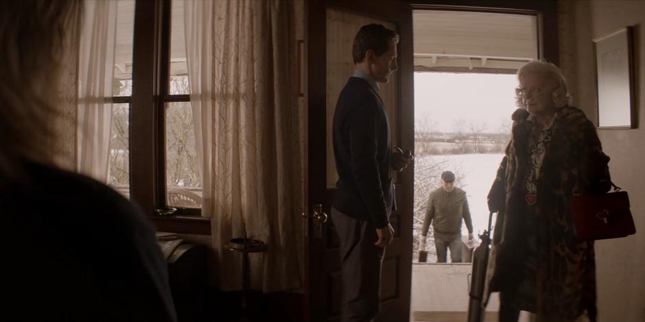 August Cartwright welcomes his mother into his home while the taxi driver carries her bags up to the porch.