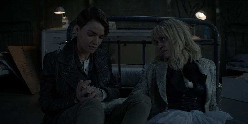 Kate holds Alice's hands while sitting next to her as she dies.