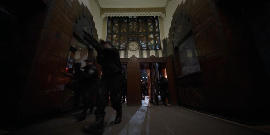 The Crows Security team rushes through the lobby searching for Alice.