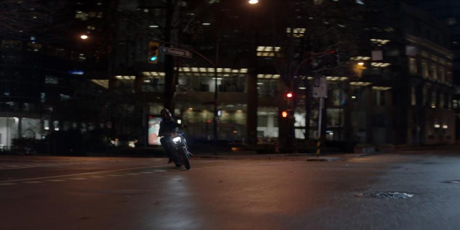 Luke rides on the Batcycle with Beth through the empty streets.