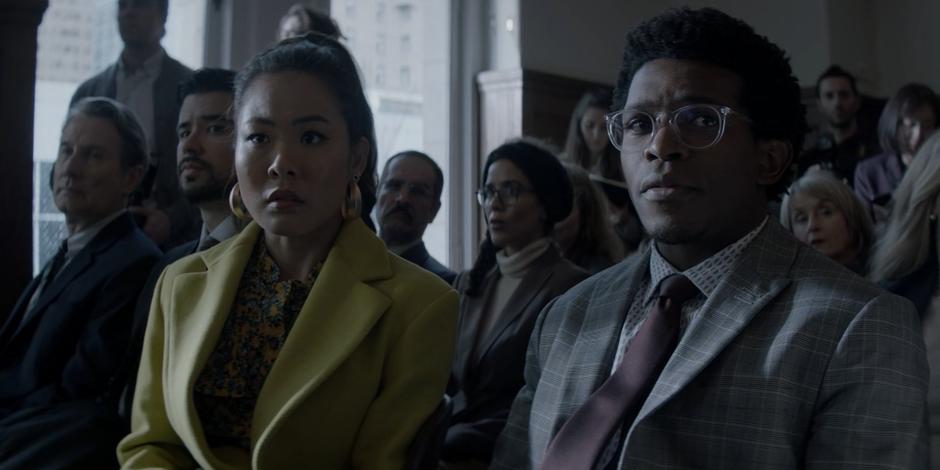 Mary and Luke watch as Reggie Harris is led into the courtroom.