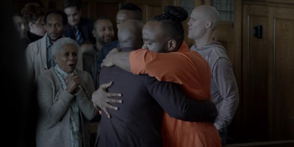 Reggie Harris hugs his lawyer after getting released while his mother watches with joy.