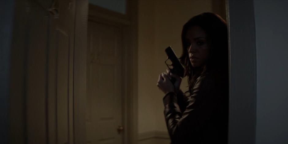 Sophie holds up her gun as she enters the apartment through the door she found open.