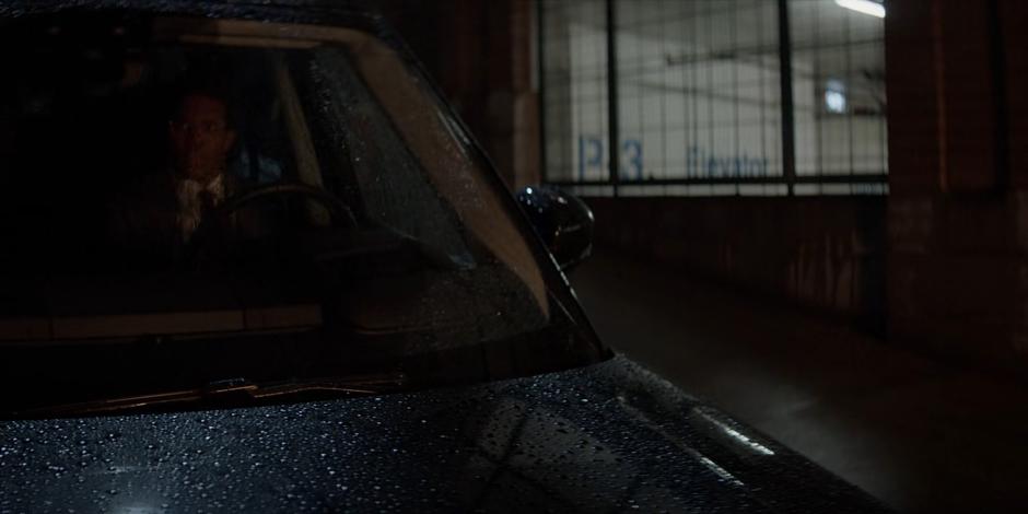 Luke watches Reggie Harris's apartment from his car across the street.