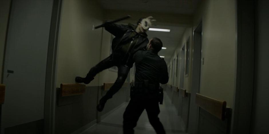 Kate leaps up to attack a guard while wearing a rabbit mask.