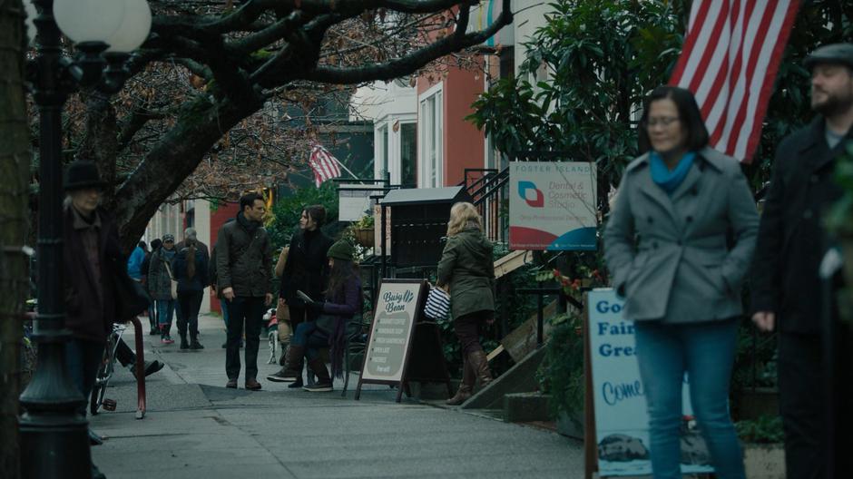 Harry and Abigael talk while walking down the street past frozen people.