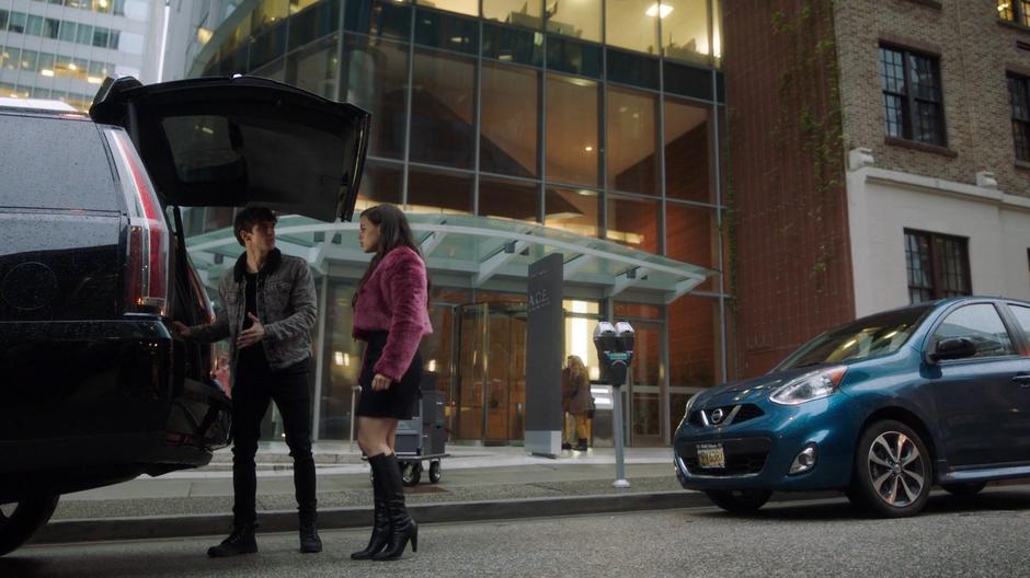 Parker talks to Maggie as he loads boxes into the back of his car.