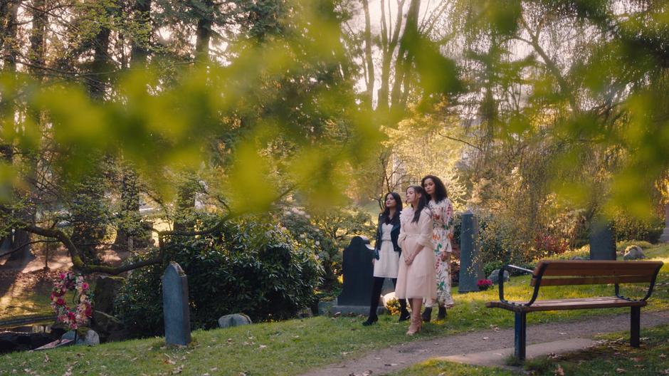 Mel, Maggie, and Macy walk through the cemetery and talk.