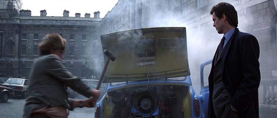 Bond watches as Jack Wade smashes the engine of his car with a sledgehammer.