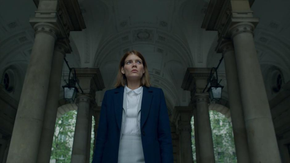 Myfanwy walks through the gate into the courtyard.