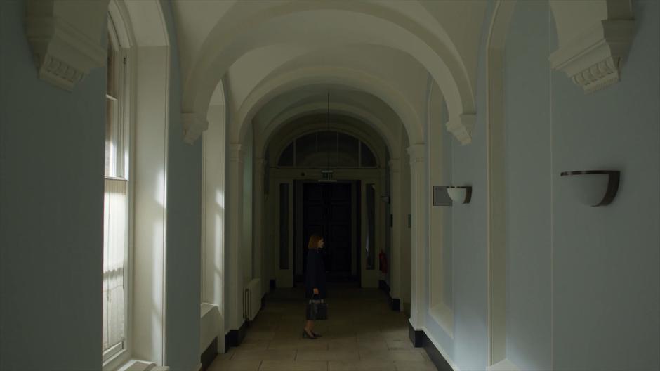 Myfanwy turns to walk up the stairs leading to the offices.