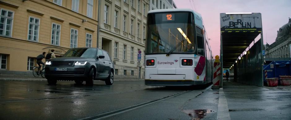 Bosley turns into the driveway behind a passing streetcar.