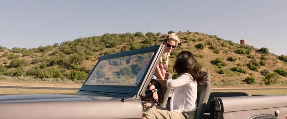 Sabina looks at Jane as they sit in the jeep waiting for the plane to land.